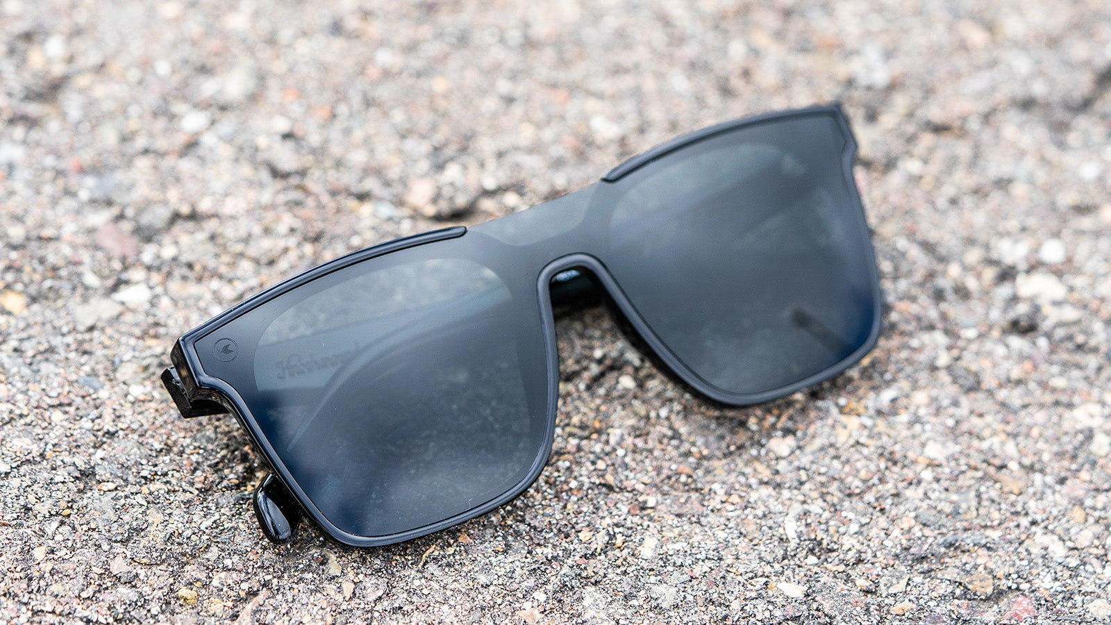 Sunglasses with a black frame with polarized black lenses, flyover